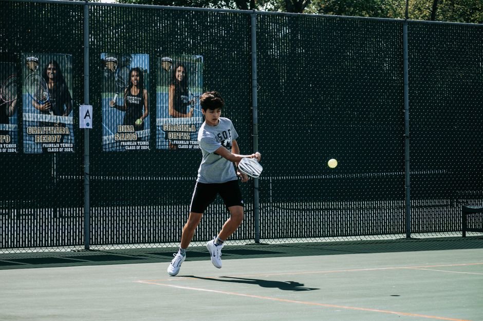 tennis player making a lateral stop on a hard court