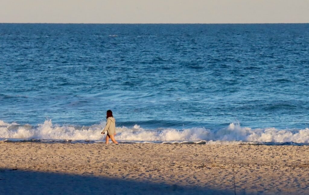 woman walking on a sandy beach in supportive sandals