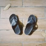 orthopedic arch support slippers on a hardwood floor