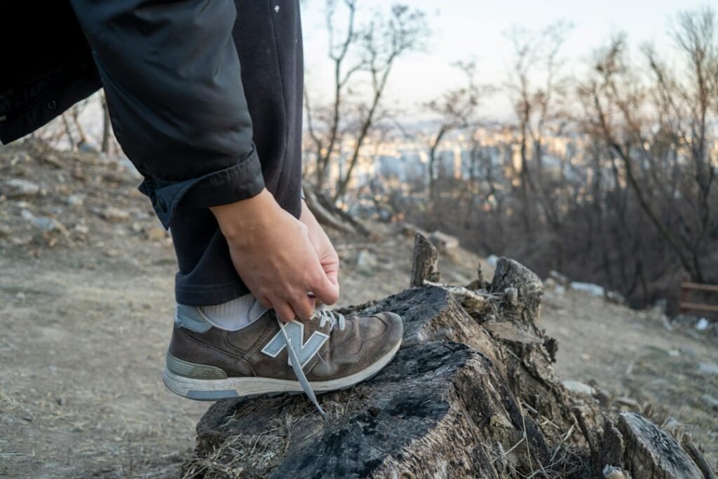 hiker adjusting hiking boots on a rocky trail